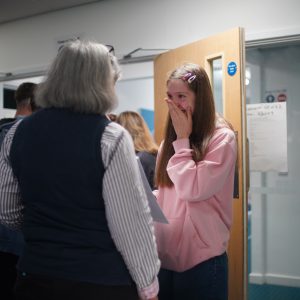 a child in disbelief and happiness at her results