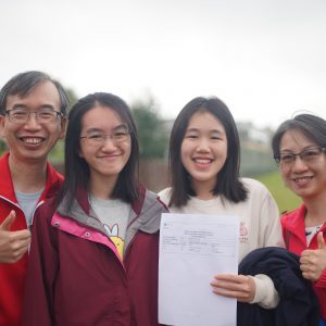 a student with her family showing thumbs up