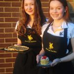 Two Queen's College students holding pancakes