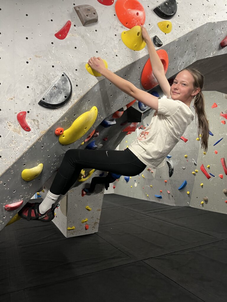 A girl on a climbing wall.