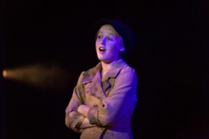 Milly Gubby performing on stage at Queen’s College, showcasing her passion for the Performing Arts.