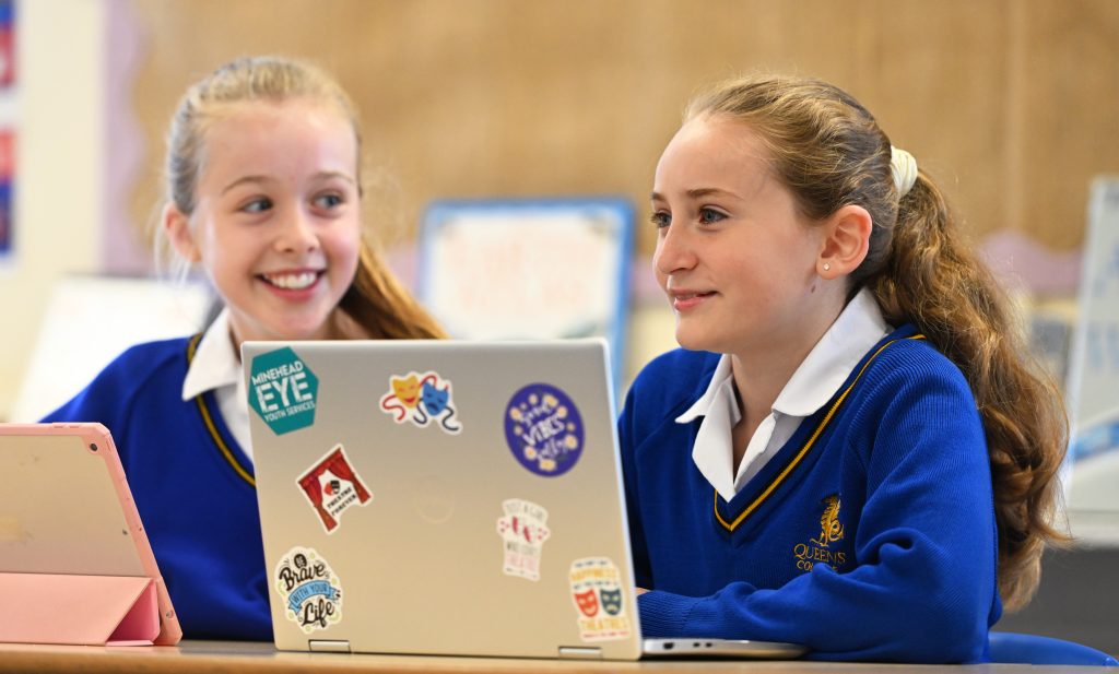 children in prep school working on a laptop.